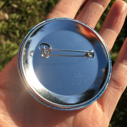 Photo showing the back of the spread smiles & sanitise badge for hygiene awareness, ideal for nurses and health care workers. Badge by Jenny Pond, JP Artwork