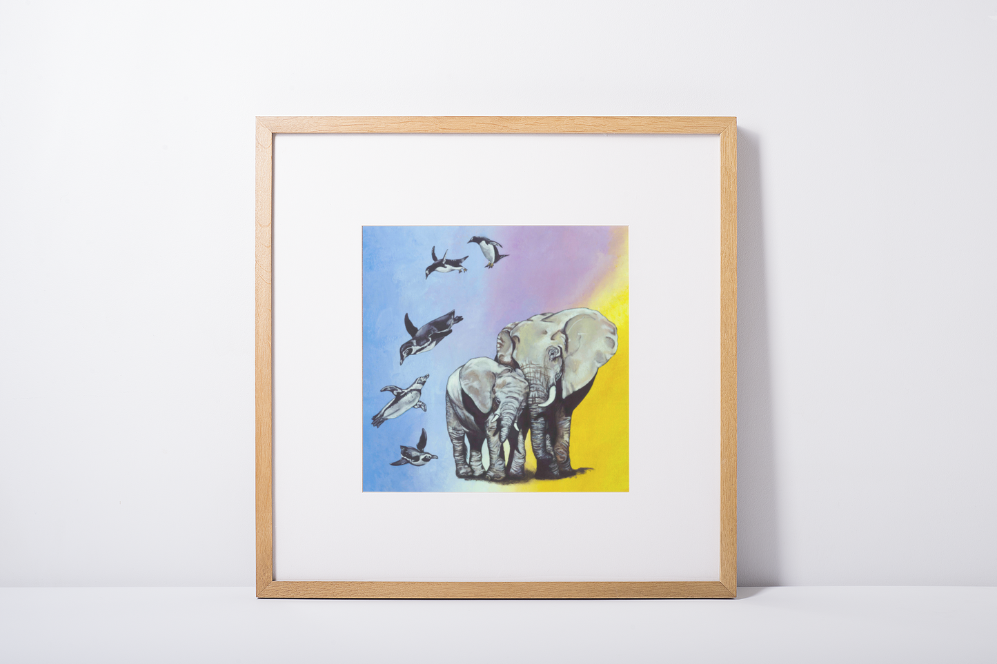 Mock Up of An Art Print featuring a mother and baby african elephant, and 5 penguins, displayed on a wall in a square pine frame. Art by Jenny Pond, JP Artwork
