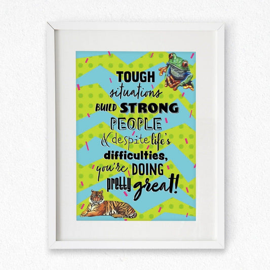 Framed mock up of an A4 Print; the design features a spotty green and blue zigzag background covered in pink confetti lines, a tree frog top right, a tiger bottom left, and the words 'Tough situations build strong people & despite life's difficulties, you're doing pretty great!' in the centre. Artwork by Jenny Pond, JPArtwork